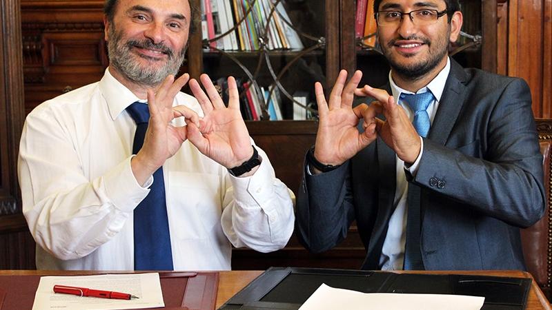 El Director de la DIBAM, Ángel Cabeza Monteira, junto a Rodrigo Campos Muñoz, (Fundación AMOMA) dicen gracias en lenguaje de señas. Los representantes de las instituciones firmantes, el director de la DIBAM, Ángel Cabeza Monteira, junto a Rodrigo Campos Muñoz, (Fundación AMOMA) dicen gracias en lenguaje de señas.