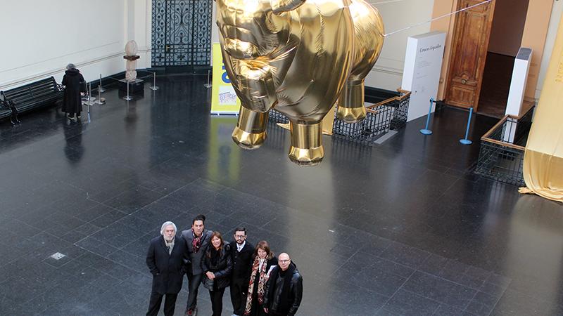 Los artistas bajo el toro dorado que flota en altura sobre el hall del Museo.