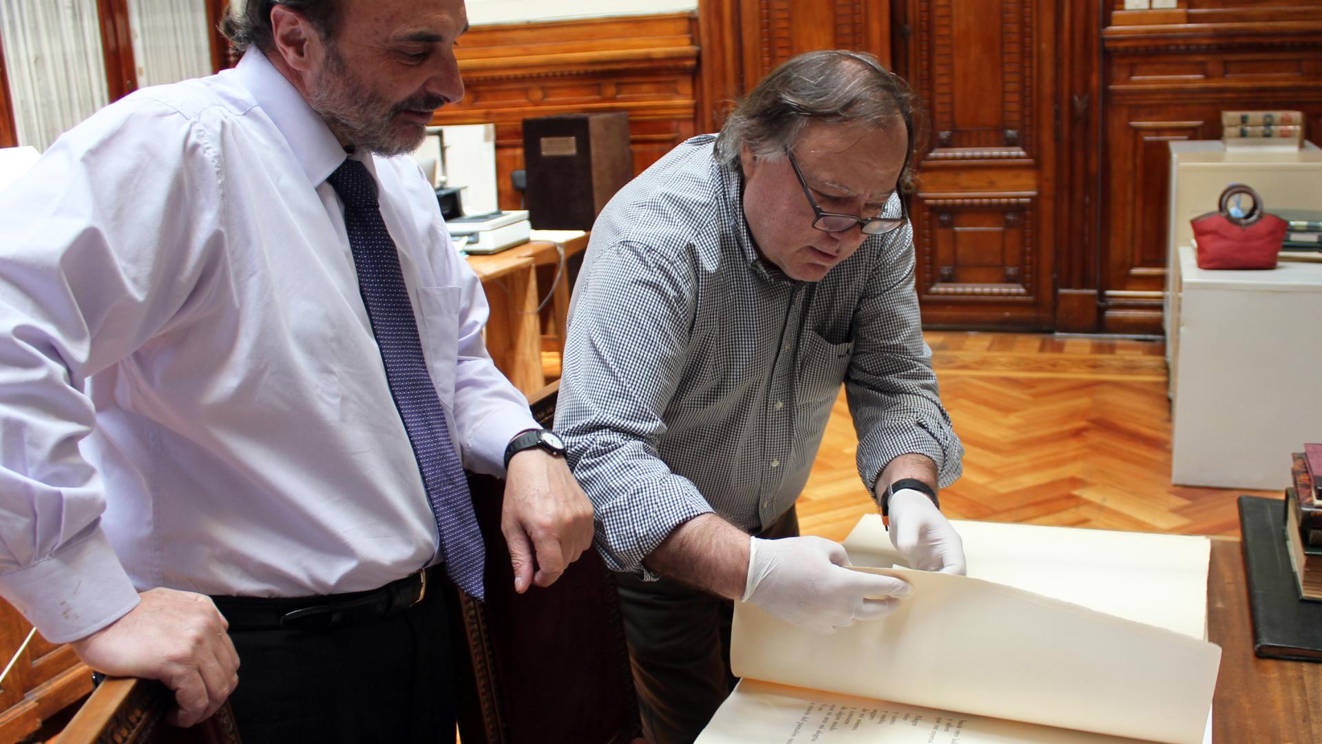 Director de la Dibam y Subdirector (s) de la Biblioteca Nacional revisan los documentos.