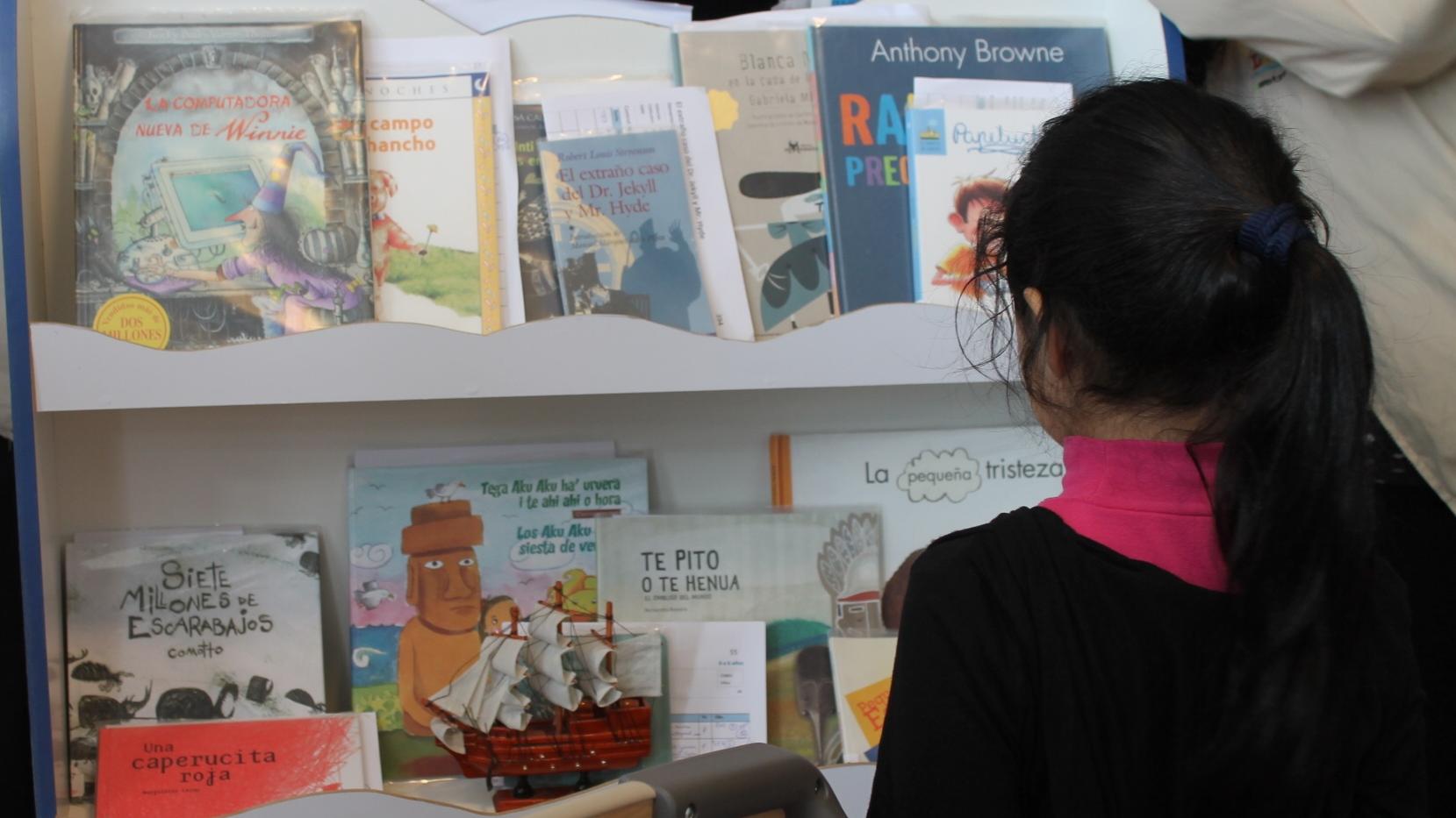 Niña de espaldas viendo libros