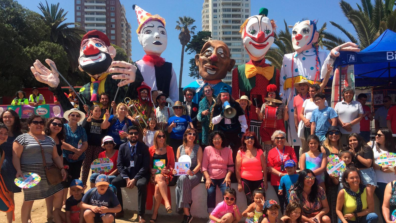 personas en la playa con marionetas de gran formato