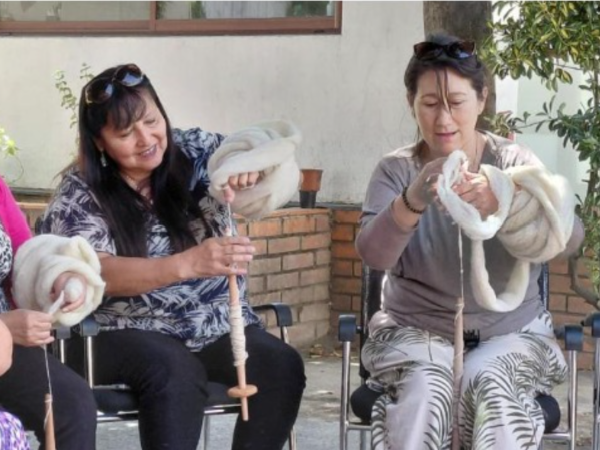 Mujeres hilando con huso tradicional