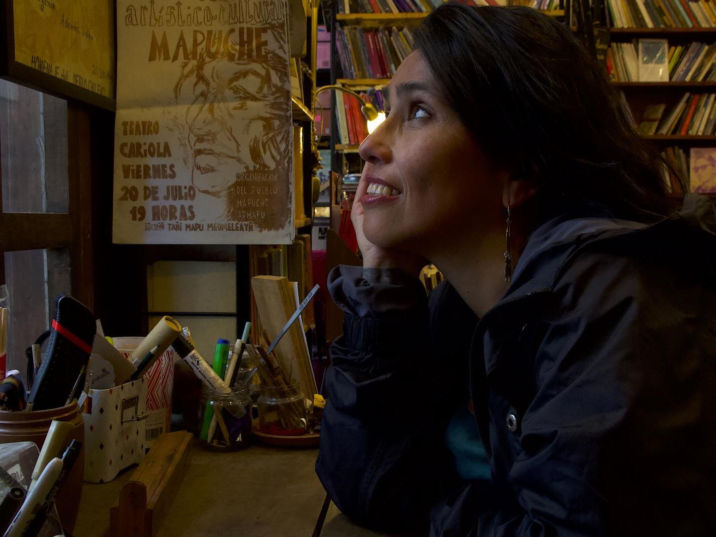 Mujer de perfil en un lugar con libros mirando hacia una ventana