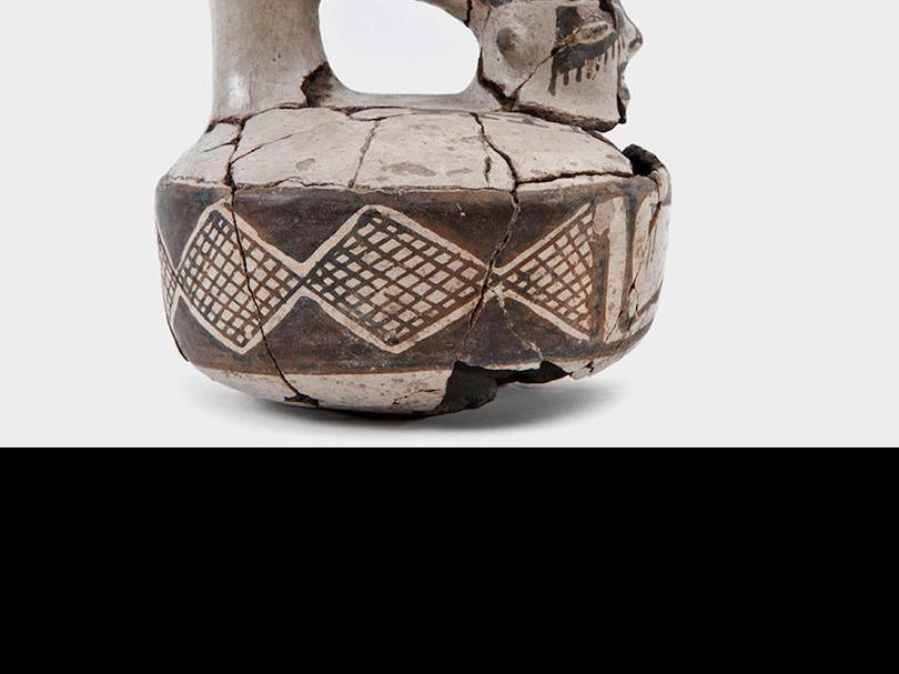 Jar with anthropomorphic features measuring 144 mm. The inside has been smoothed and the outside polished with white slip. It is decorated with brown and black geometric figures. It is from the Late Period and its horizontal band corresponds to the decorative patterns that characterize the stage in which forms from the pre-Inca period coexisted with the influence of Cusco.