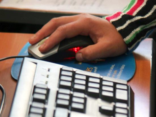Persona moviendo un mouse frente al computador