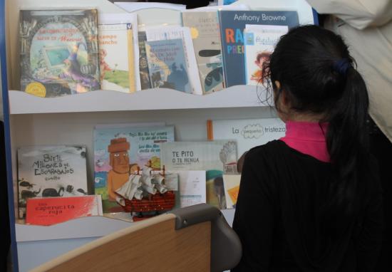 Niña de espaldas viendo libros