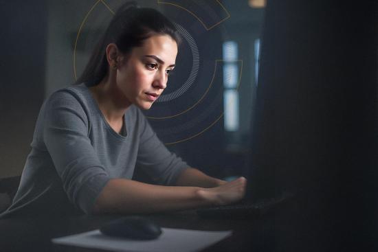 Imagen de mujer frente escribiendo frente a un computador