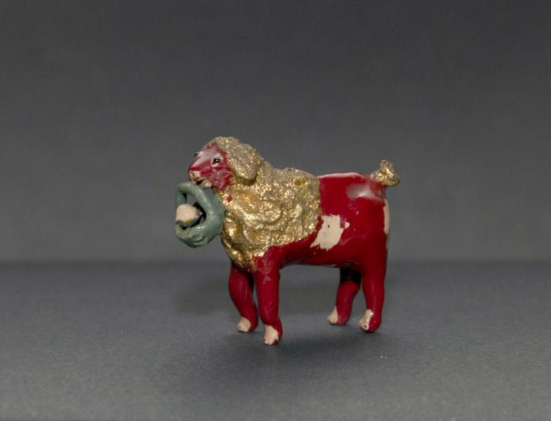 Perro sonajero en miniatura, de cola dorada y canasto en el hocico