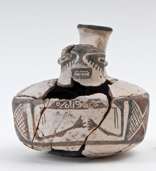 Jar with anthropomorphic features measuring 144 mm. The inside has been smoothed and the outside polished with white slip. It is decorated with brown and black geometric figures. It is from the Late Period and its horizontal band corresponds to the decorative patterns that characterize the stage in which forms from the pre-Inca period coexisted with the influence of Cusco.