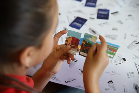 Niña toma entre sus manos y mira piezas de material didáctico